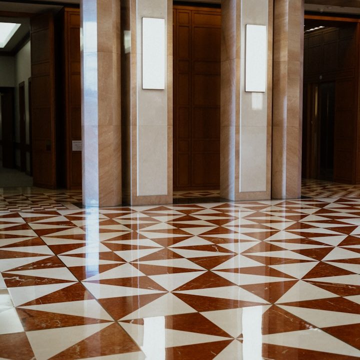 Muster aus roten und weißen Dreiecken auf einem glänzenden Boden in einem Foyer.