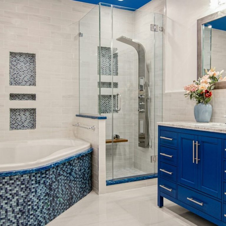 Modern Badezimmer mit blauer Badewanne, Duschkabine und elegantem Waschtisch.